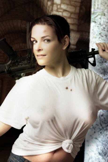 Brunette cosplayer releases her big tits while holding a rifle