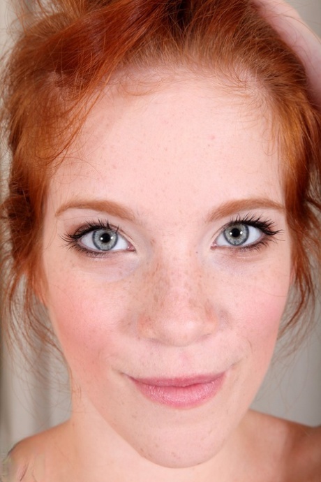 Attractive redhead with freckles Roxy Rush reveals her body on a couch